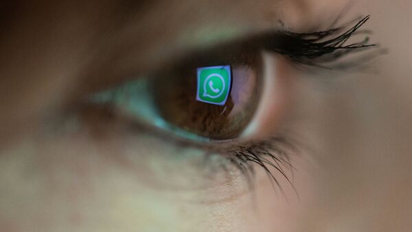 An illustration picture taken on March 22, 2018 in Paris shows a close-up of the WhatsApp logo in the eye of an AFP staff member posing while she looks at a flipped logo of WhatsApp - Sputnik International