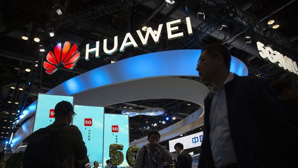 Attendees walk past a display for 5G services from Chinese technology firm Huawei at the PT Expo in Beijing, Thursday, Oct. 31, 2019 - Sputnik International