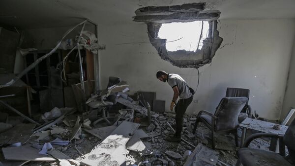A Palestinian man inspects a damaged building in Gaza City on November 12, 2019 - Sputnik International