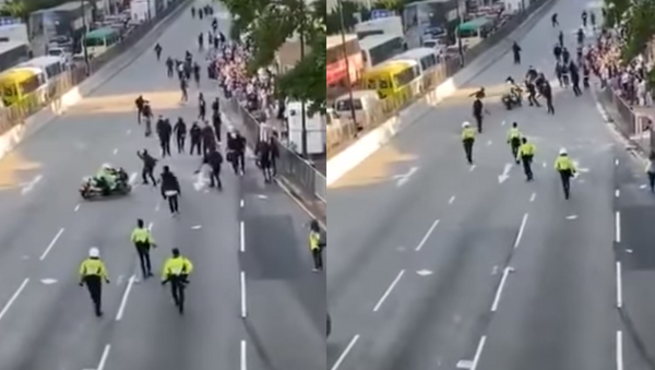 The Hong Kong police are facing backlash online over a viral video of an officer driving into a group of protesters on the road. - Sputnik International