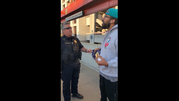 A BART officer from California is seen in cellphone footage confronting transit rider Steve Foster over his decision to eat a breakfast sandwich on the train platform, which is a citable offense per the state's law. - Sputnik International