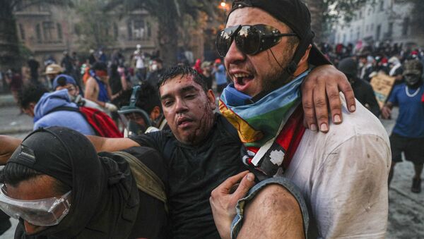 An injured anti-government demonstrator in Santiago - Sputnik International