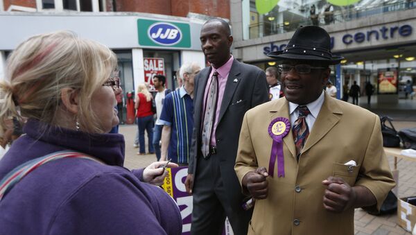 Candidate for the euro-sceptic United Kingdom Independence Party Winston McKenzie, right, speaks to a woman as UKIP supporters campaign for the European and local elections in Croydon, south London, Tuesday, May 20, 2014 - Sputnik International