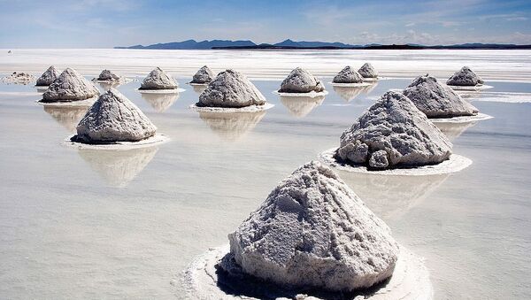 Salt mounds in Salar de Uyuni, Bolivia. The Salar de Uyuni is the world's largest (12 000 km²) and highest (3 700 m) salt flat, ca. 25 times as large as the Bonneville Salt Flats. It's the remnant of a prehistoric lake surrounded by mountains without drainage outlets. Salt is harvested in the traditional method: the salt is scraped into small mounds for water evaporation and easier transportation, dried over fire, and finally enriched with iodine. - Sputnik International