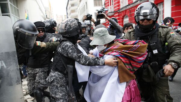 A backer of former President Evo Morales scuffles with police in La Paz, Bolivia, Wednesday, Nov. 13, 2019. The opposition senator who has claimed Bolivia's presidency Jeanine Anez, faces the challenge of stabilizing the nation and organizing national elections within three months at a time of political disputes that pushed Morales to fly off to self-exile in Mexico after 14 years in power.  - Sputnik International