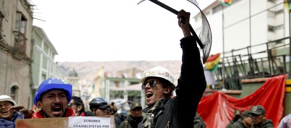 Opponents of former Bolivian President Evo Morales hold shields at a barricade set up by protesters outside presidential palace in La Paz, Bolivia, Monday, Nov. 11, 2019. - Sputnik International