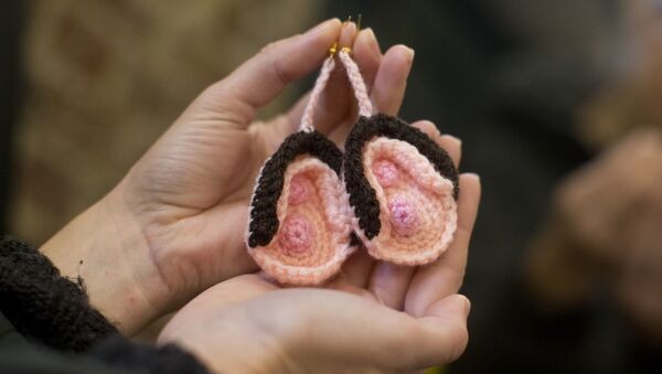 A visitor looks at a pair of crochet vulva earrings on sale during the press preview of the new Vagina Museum in Camden market, north London on November 14, 2019 - Sputnik International