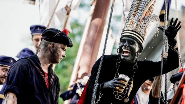A man wearing a controversial makeup colouring blackface and called the savage gestures during a folk parade Ducasse of Ath in Ath, Belgium on August 25, 2019 - Sputnik International