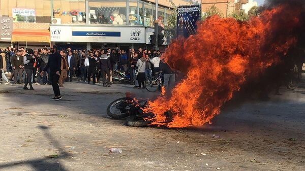 Iranian protesters gather around a burning motorcycle during a demonstration against an increase in gasoline prices in the central city of Isfahan, on November 16, 201 - Sputnik International