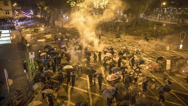 Protesters react as police fire tear gas while they attempt to march towards Hong Kong Polytechnic University in Hung Hom district of Hong Kong on November 18, 2019 - Sputnik International