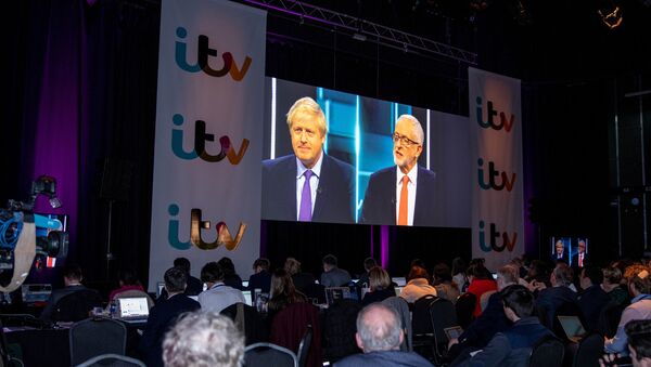 Boris Johnson and Jeremy Corbyn are seen on a screen as journalists watch tonight's debate in the 'Spin Room' ahead of general election in London, Britain, November 19, 2019 - Sputnik International