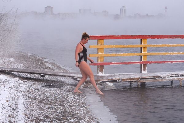 A woman prepares to open the season of ice water swimming in the Yenisey River in Krasnoyarsk - Sputnik International