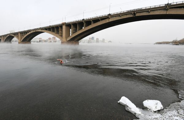 A man swims during the opening of the cold water swimming season in Krasnoyarsk - Sputnik International