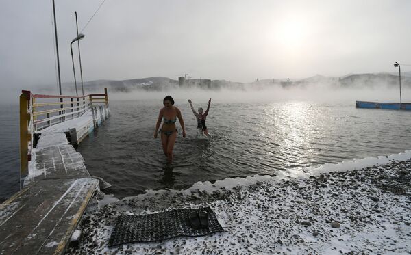 Women pose for photos during preparations for the cold water swimming competitions in the Yenisei River in Krasnoyarsk. Russian 'morzhi' ('walruses') say that cold water swimming has many health benefits.  - Sputnik International