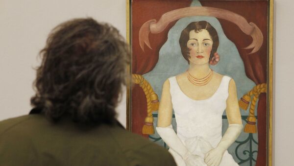 A visitor looks at a painting by Mexican artist Frida Kahlo titled Portrait of a lady in white during the opening of a show of her works on August 31, 2010 in Vienna - Sputnik International