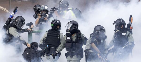 Police in riot gear move through a cloud of smoke as they detain a protester at the Hong Kong Polytechnic University Police in riot gear move through a cloud of smoke as they detain a protester at the Hong Kong Polytechnic University - Sputnik International
