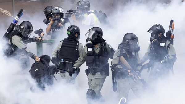 Police in riot gear move through a cloud of smoke as they detain a protester at the Hong Kong Polytechnic University  - Sputnik International