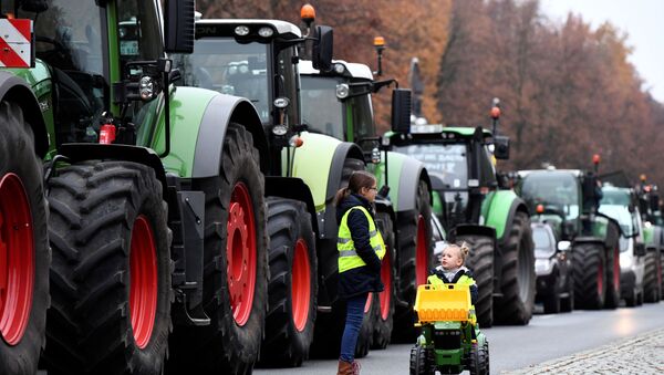 Amarence and Henriette, two girls of a farmer's family from the town of Rathenow, walk past tractors near Brandenburg Gate as farmers gather for a demonstration against the agricultural policies of the federal government, in Berlin, Germany, November 26, 2019.  - Sputnik International