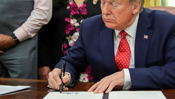 U.S. President Donald Trump signs an Executive Order to address the issue of missing and murdered Native Americans during a ceremony in the Oval Office at the White House in Washington, U.S. November 26, 2019.  - Sputnik International
