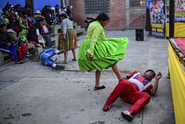 Bolivian wrestler Lidia Flores (2-R), aka Dina, The Queen of the Ring and Ana Luisa Yujra (2-L), aka Jhenifer Two Faces, both members of the Fighting Cholitas, fight against male wrestlers at Sharks of the Ring wrestling club in El Alto, Bolivia, on November 24, 2019. - Sputnik International