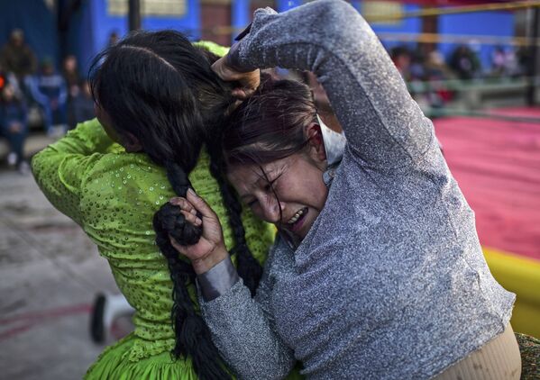 Bolivian wrestler Ana Luisa Yujra (R), aka Jhenifer Two Faces and Lidia Flores, aka Dina, The Queen of the Ring, both members of the Fighting Cholitas, fight at Sharks of the Ring wrestling club in El Alto, Bolivia, on November 24, 2019. - Sputnik International