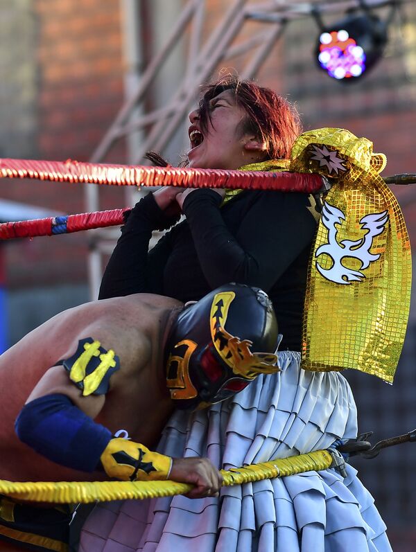 Bolivian wrestler Blanca Perez, aka Katy The Beautiful, a member of the Fighting Cholitas, fights with a male wrestler at Sharks of the Ring wrestling club in El Alto, Bolivia, on November 24, 2019.  - Sputnik International