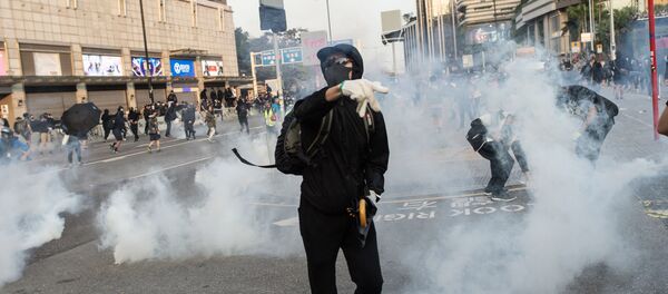Pro-democracy protesters react after police fired tear gas during a march from the Tsim Sha Tsui district to Hung Hom in Hong Kong on December 1, 2019. - Tens of thousands of black-clad protesters flooded into the streets of Hong Kong on December 1, ending a brief election lull and demanding the government make concessions after pro-democracy candidates won a landslide victory. Pro-democracy protesters react after police fired tear gas during a march from the Tsim Sha Tsui district to Hung Hom in Hong Kong on December 1, 2019. - Tens of thousands of black-clad protesters flooded into the streets of Hong Kong on December 1, ending a brief election lull and demanding the government make concessions after pro-democracy candidates won a landslide victory. - Sputnik International