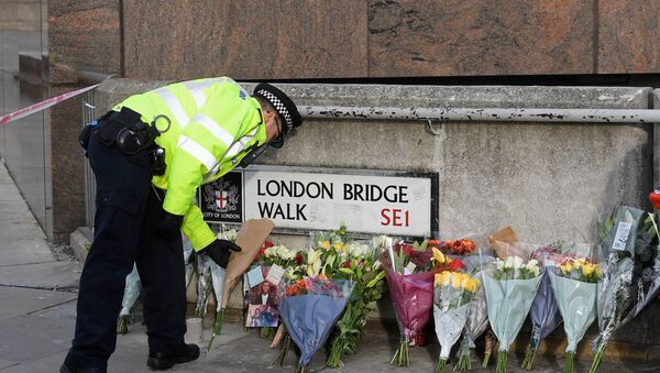 A police officer places a floral tribute near the scene of a stabbing on London Bridge, in London - Sputnik International