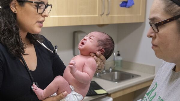 Jasmine Saavedra, left, a pediatrician at Esperanza Health Centers in Chicago examines Alondra Marquez, a newborn baby - Sputnik International