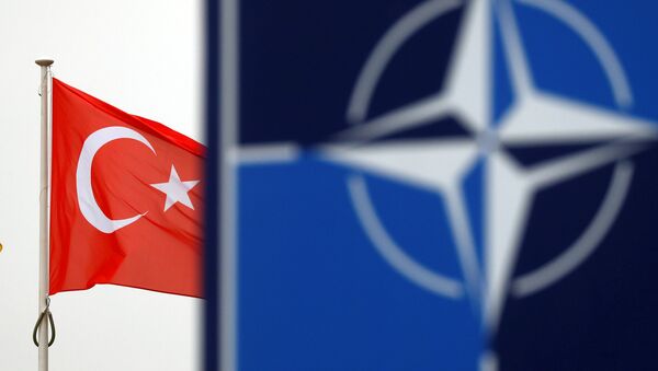 A Turkish flag flies next to NATO logo at the Alliance headquarters in Brussels, Belgium - Sputnik International