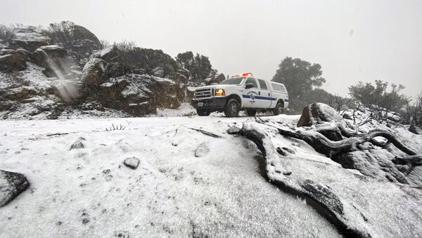 This photo tweeted by the Santa Barbara County Fire Department shows a Santa Barbara Fire Department truck along E. Camino Cielo as snow falls at the 3,500 foot level on the fire footprint in Santa Barbara, Calif. Thursday, Nov. 28, 2019. Wintry weather temporarily loosened its grip across much of the U.S. just in time for Thanksgiving, after tangling holiday travelers in wind, ice and snow and before more major storms descend Friday. (Mike Eliason/Santa Barbara County Fire via AP) - Sputnik International