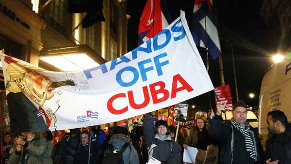 Rob Miller of Cuba Solidarity Campaign holds banner as anti-NATO demonstration moves from Trafalgar Sq to Buckingham Palace - Sputnik International