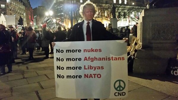 Man with Trump mask and sign opposed to nukes and war and NATO - Sputnik International