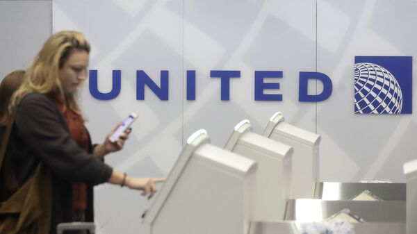 A woman uses a United Airlines kiosk at San Francisco International Airport in San Francisco, Tuesday, Nov. 26, 2019.  - Sputnik International
