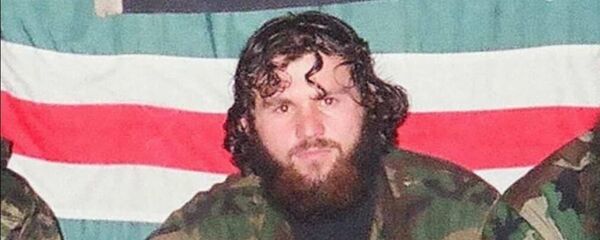 Zelimkhan Khangoshvili is pictured against the backdrop of the flag of the unrecognised Chechen Republic of Ichkeria during the Chechen conflict. - Sputnik International