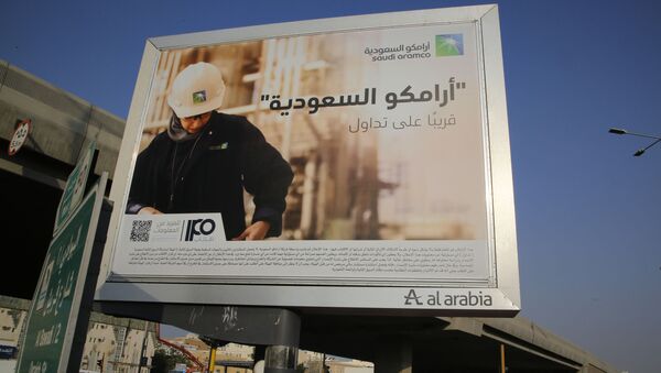 A man walks under a billboard displaying an advertisement for Saudi Arabia's state-owned oil giant Aramco with Arabic reading: Saudi Aramco, soon on stock exchange in Jiddah, Saudi Arabia, Tuesday, Nov. 12, 2019 - Sputnik International