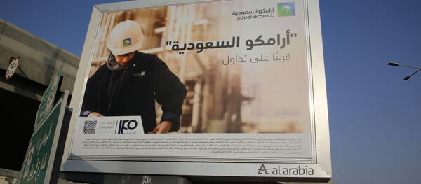 A man walks under a billboard displaying an advertisement for Saudi Arabia's state-owned oil giant Aramco with Arabic reading: Saudi Aramco, soon on stock exchange in Jiddah, Saudi Arabia, Tuesday, Nov. 12, 2019 - Sputnik International