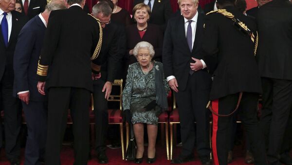 Britain's Queen Elizabeth II, centre, takes her seat with Britain's Prime Minister Boris Johnson and Chancellor of Germany Angela Merkel, behind, before a formal group photo during a formal reception for the heads of the NATO countries, at Buckingham palace in London Tuesday Dec. 3, 2019 - Sputnik International