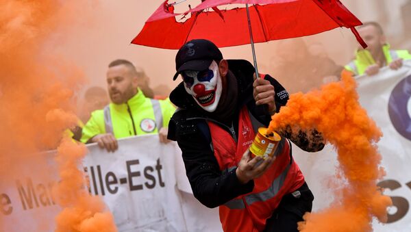 A man wearing a clown mask and waving a smoke bomb takes part in a demonstration to protest against the pension overhauls, in Marseille, southern France, on December 5, 2019 as part of a national general strike. - Sputnik International