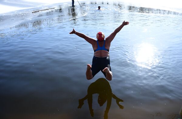 A woman jumps into a partly frozen lake at a park in Shenyang in China's northeast Liaoning province on December 2, 2019.  - Sputnik International