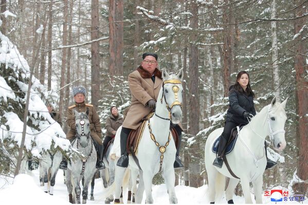 North Korean leader Kim Jong Un and his wife ride horses as they visit battle sites in areas of Mt Paektu, Ryanggang, North Korea, in this undated picture released by North Korea's Central News Agency (KCNA) on December 4, 2019.      - Sputnik International