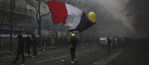 A man waves a French flag during a demonstration in Paris, Thursday, Dec. 5, 2019. Small groups of protesters are smashing store windows, setting fires and hurling flares in eastern Paris amid mass strikes over the government's retirement reform. A man waves a French flag during a demonstration in Paris, Thursday, Dec. 5, 2019. Small groups of protesters are smashing store windows, setting fires and hurling flares in eastern Paris amid mass strikes over the government's retirement reform. - Sputnik International