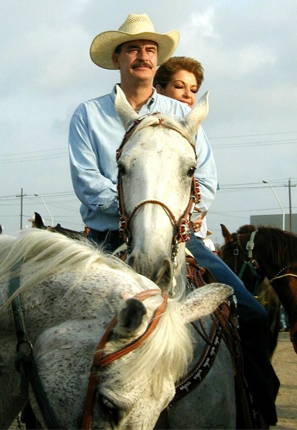 Mexican President Vicente Fox sits atop his horse El Rey with First Lady Martha Sahagun during a ride with Mexican border governors outside of Nuevo Laredo, Mexico, Sunday, April 21, 2002 - Sputnik International