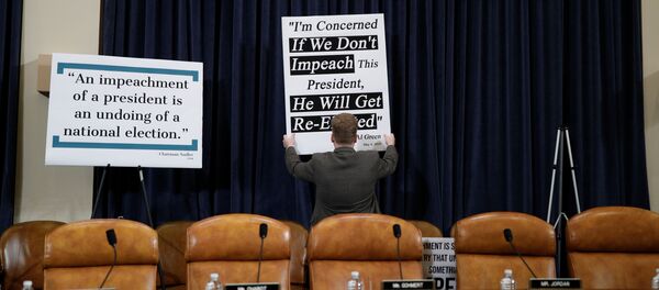 A Republican staff member adjusts a sign behind Republican seats on the dais at the first House Judiciary Committee hearing on the impeachment inquiry into U.S. President Donald Trump - Sputnik International