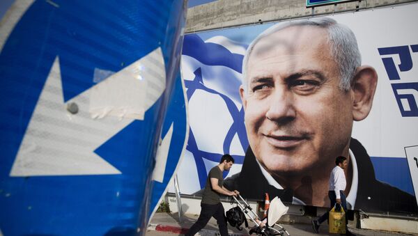 FILE - In this April 7, 2019 file photo, a man walks by an election campaign billboard showing Israel's Prime Minister Benjamin Netanyahu, the Likud party leader, in Tel Aviv, Israel.  - Sputnik International