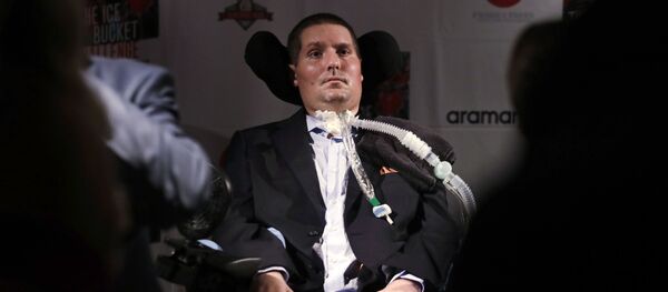   --FILE-- In this Sept. 18, 2017 photograph, Pete Frates, who is stricken with amyotrophic lateral sclerosis, or ALS, and is the inspiration of the Ice Bucket Challenge, listens to a guest at Fenway Park in Boston. - Sputnik International