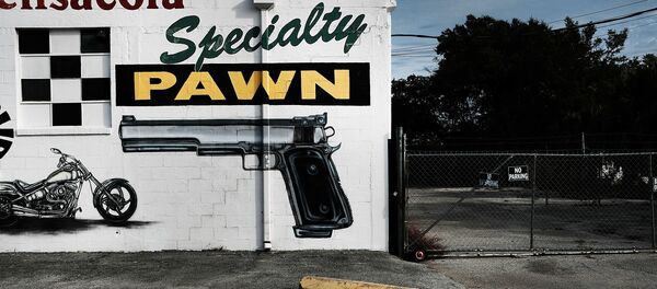   A pawn shop wall is painted with guns and other items in a struggling neighborhood in Pensacola, Florida, 3 December 2016. - Sputnik International