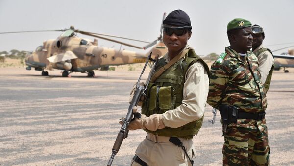 Niger army soldiers stand guard next to a Niger's Air Force Mi-35P attack helicopter on the tarmac in Diffa, southeastern Niger - Sputnik International
