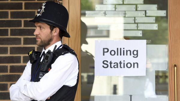 A police officer is stationed outside a polling station at Cubitt Town Infant and Junior School on the Isle of Dogs in London, as people cast their votes in the general election (File) - Sputnik International