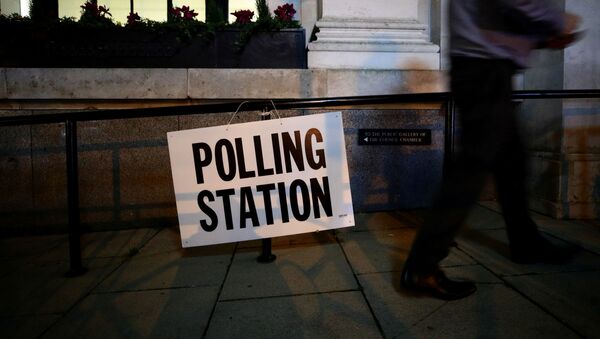 A man walks past a sign outside a polling station on general election day in London, Britain, December 12, 2019 - Sputnik International